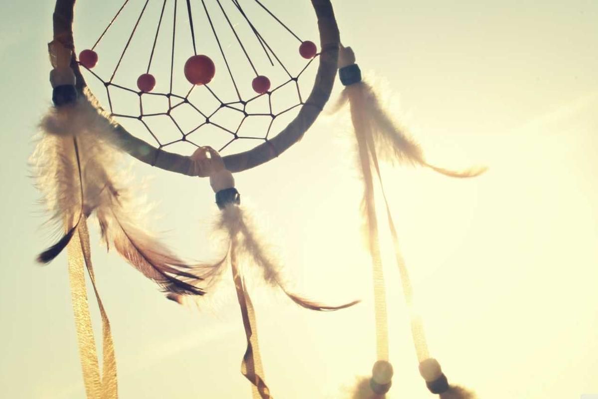 Dreamcatcher with feathers and beads illuminated by golden sunlight, symbolizing the Embera Village Cultural Experience in Panama City, Panama.