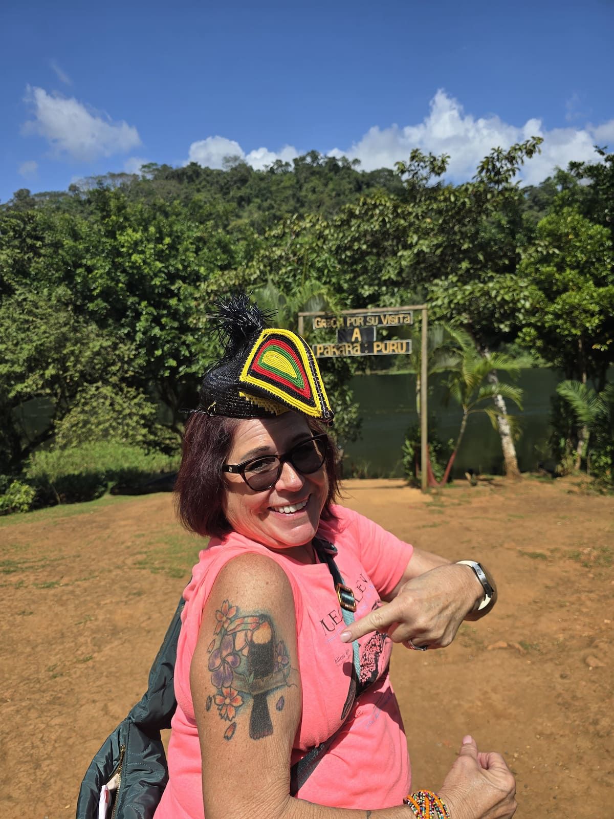 Woman wearing traditional Embera hat at Pakará Purú village entrance, showcasing cultural experience in Panama.