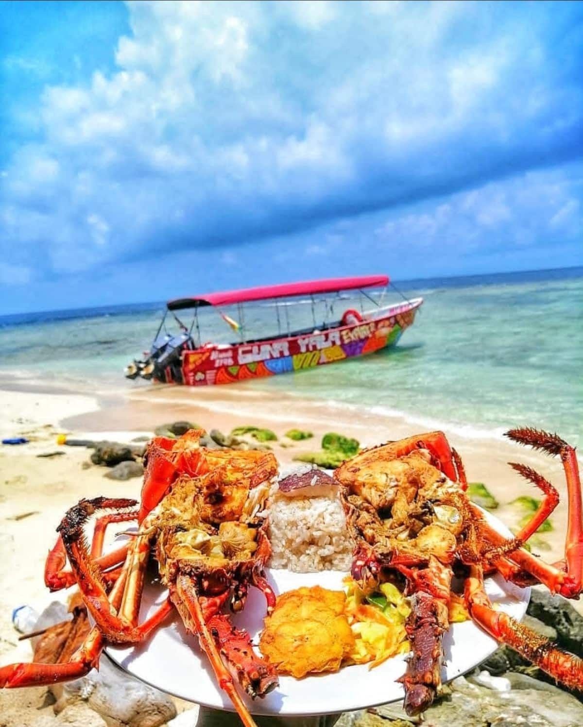 Grilled lobsters served on a beach with a colorful boat in the background at San Blas Islands Day Tour Guna Yala, Panama City, Panama
