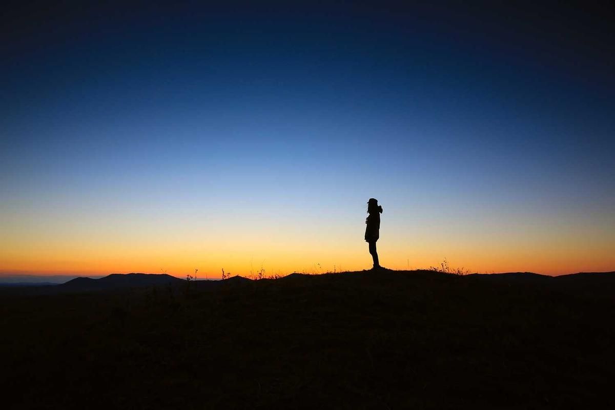 Silhouette of a person standing on a hill at sunset during the Portobelo Afro Caribbean tour in Panama City, Panama.