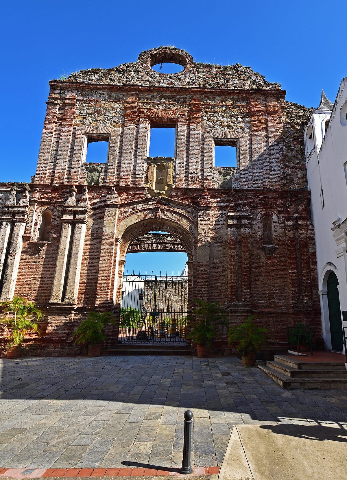 Recorrido fotográfico en Casco Antiguo: Explora las ruinas históricas de una iglesia colonial en Ciudad de Panamá, rodeada de plantas en macetas y cielos azules claros.