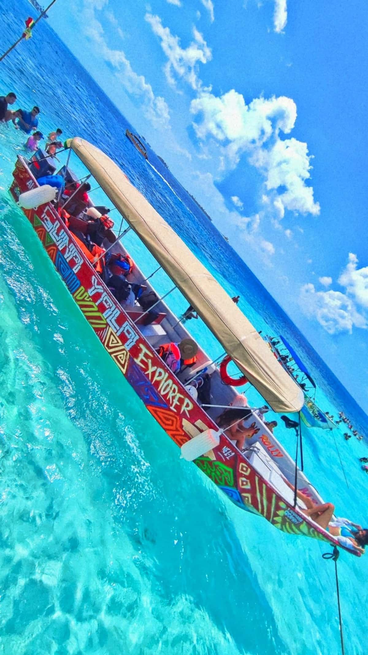 Colorful Sunset Yala Explorer boat with passengers enjoying turquoise waters under a sunny sky during a photowalk in Panama City.