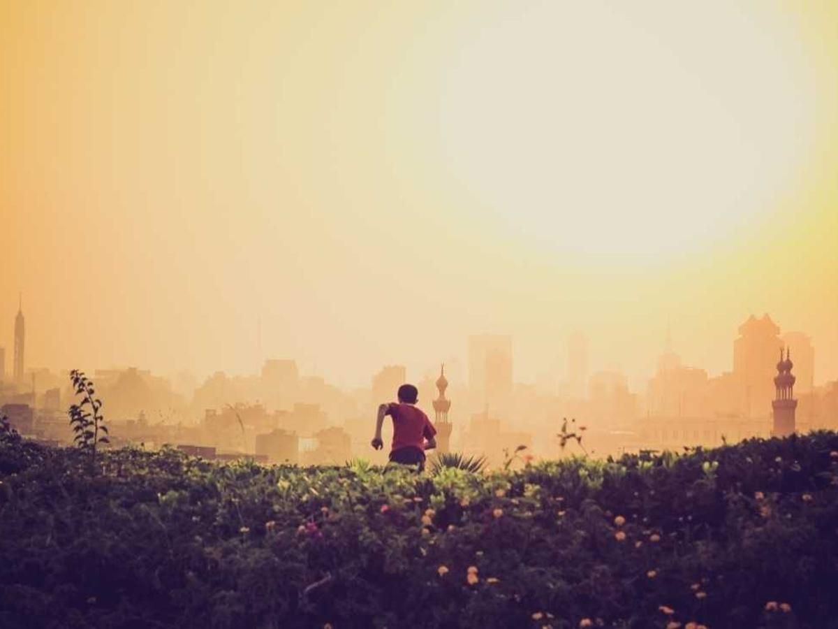 Runner silhouetted against a golden sunset with the Casco Viejo skyline in Panama City, Panama