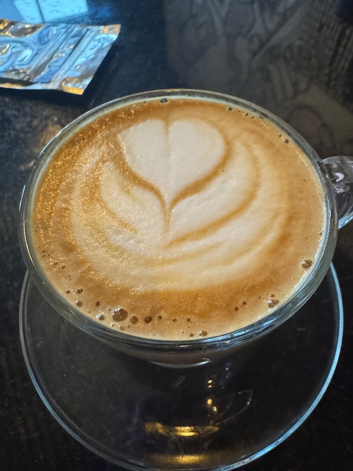 Geisha coffee latte art featuring a heart design, served in a clear glass cup at Bandits Adventure Tours Panama's Casco Viejo location