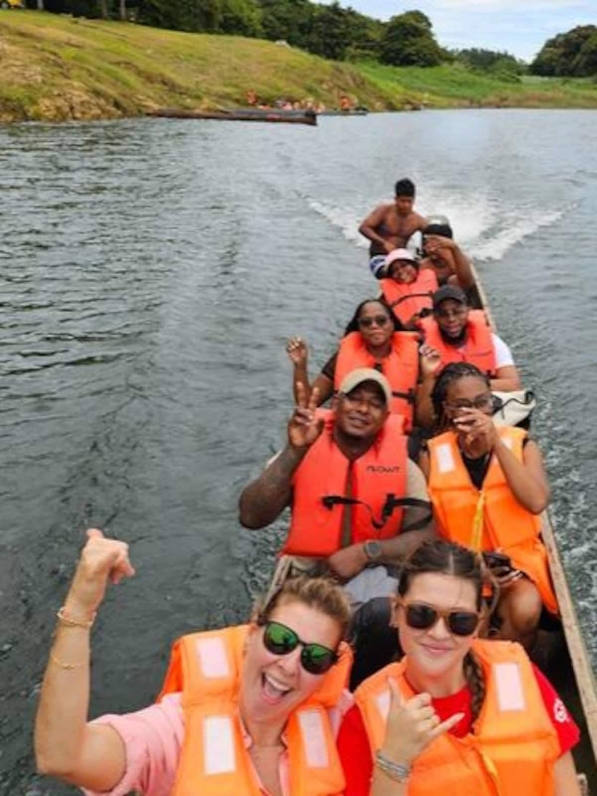 Group of tourists kayaking in a canoe at the Embera Village in Panama, wearing orange life jackets and enjoying the scenic river adventure.