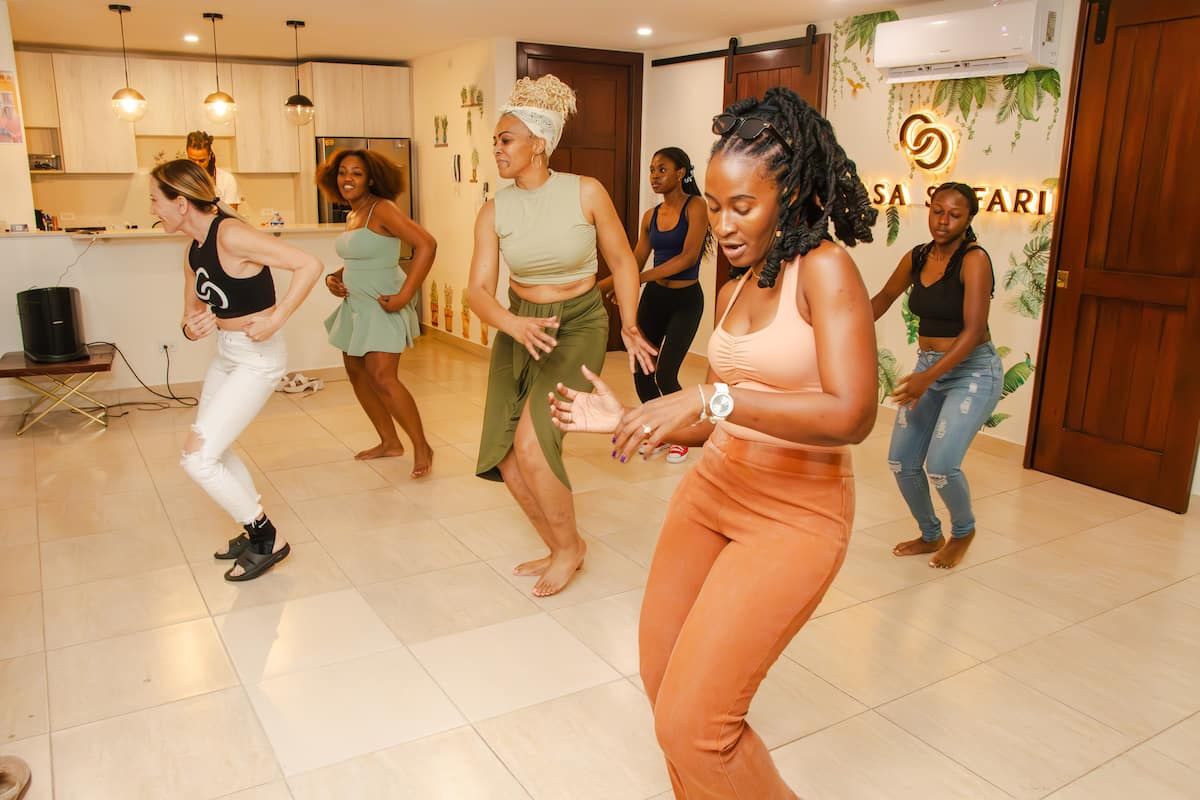 Women learning salsa dance moves in a bright studio at Salsa Safari in Panama City, Panama.