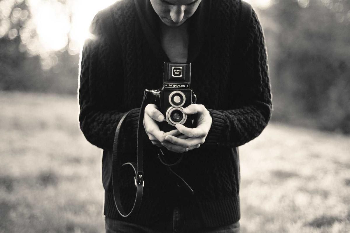 Person holding a vintage Argoflex camera in a natural setting, capturing the essence of adventure photography in Panama's rainforest.