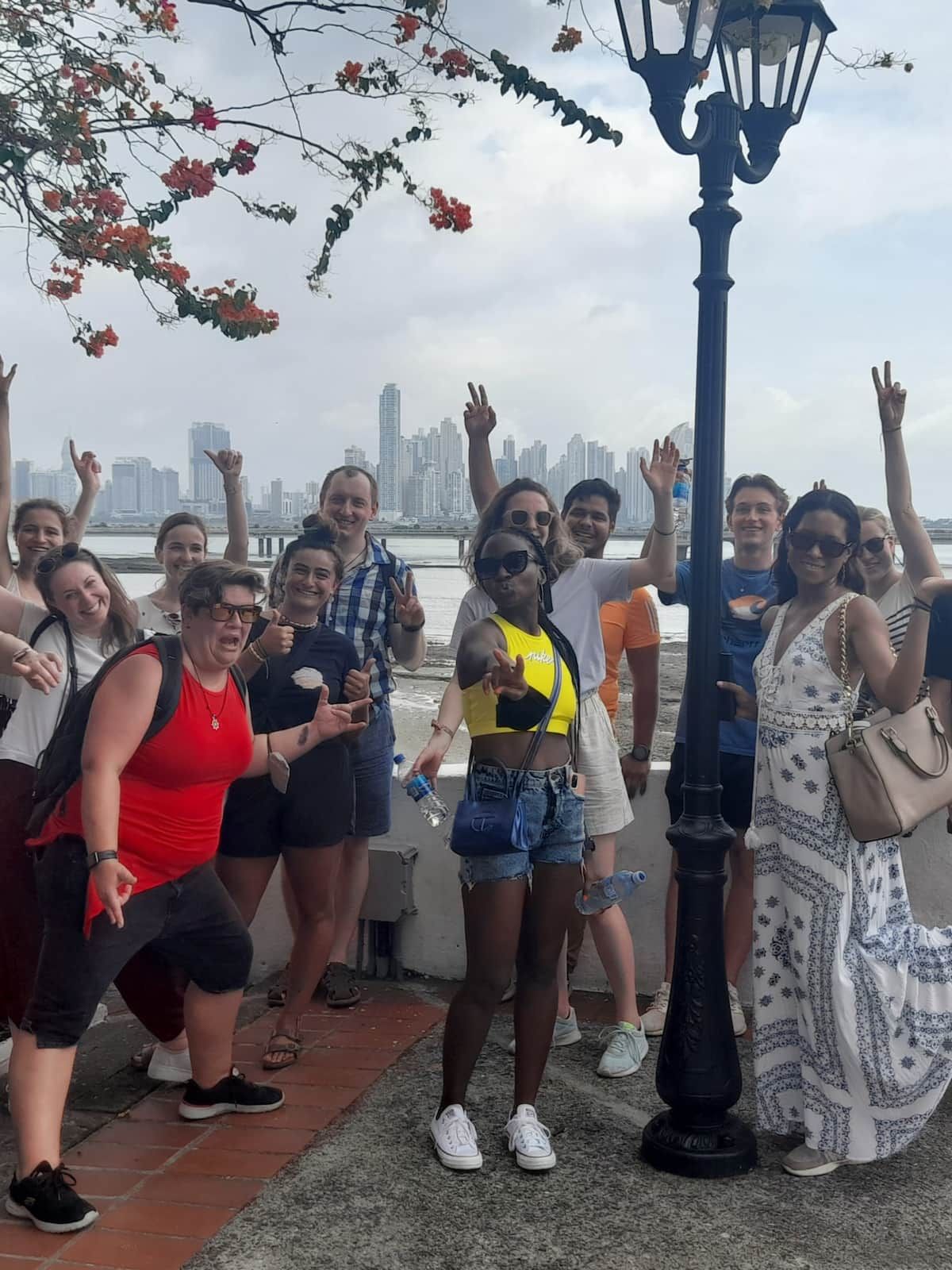 Group of tourists posing for a photo in front of the Panama City skyline during the Panama Canal Locks Casco Viejo Tour