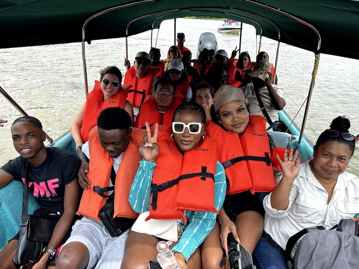 Group of tourists wearing orange life jackets enjoying a boat tour on the Panama Canal in Panama City, Panama.