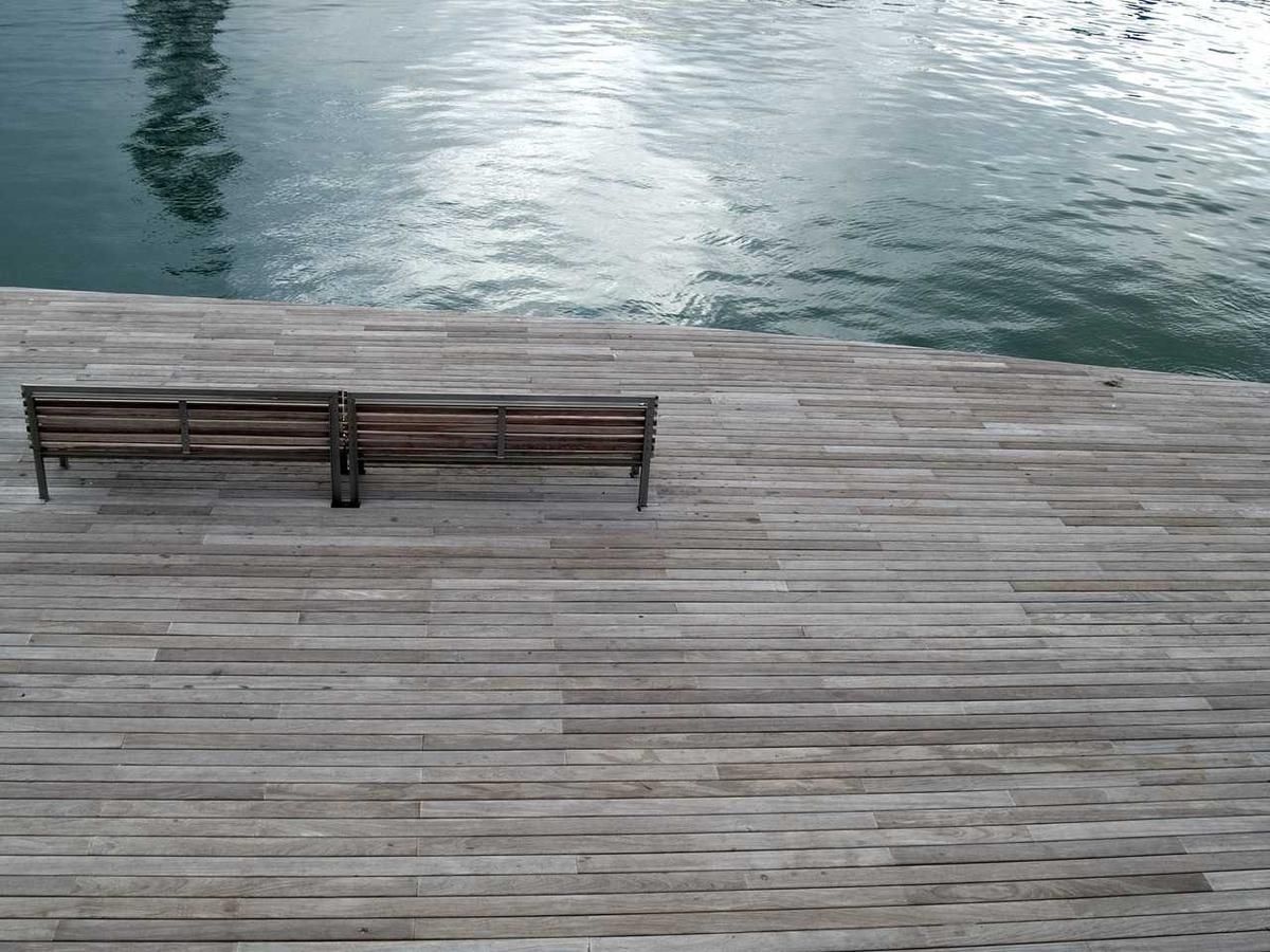 Wooden bench on a dock overlooking calm canal waters in Panama City, offering a peaceful spot for reflection and relaxation during the Canal City Tour.