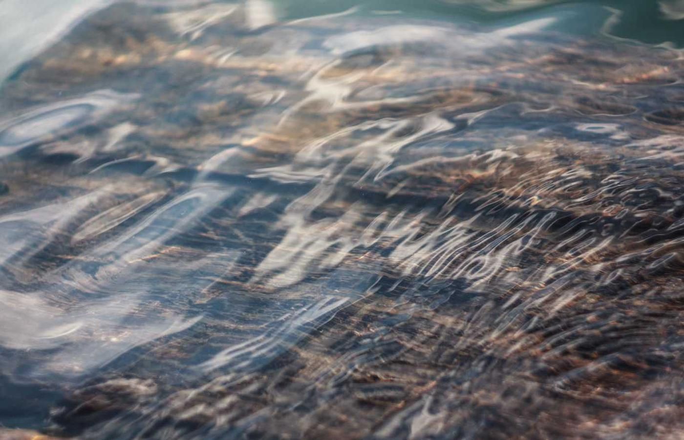 Close-up of clear, rippling water over rocks in Panama City, showcasing the natural beauty of the canal city tour experience.