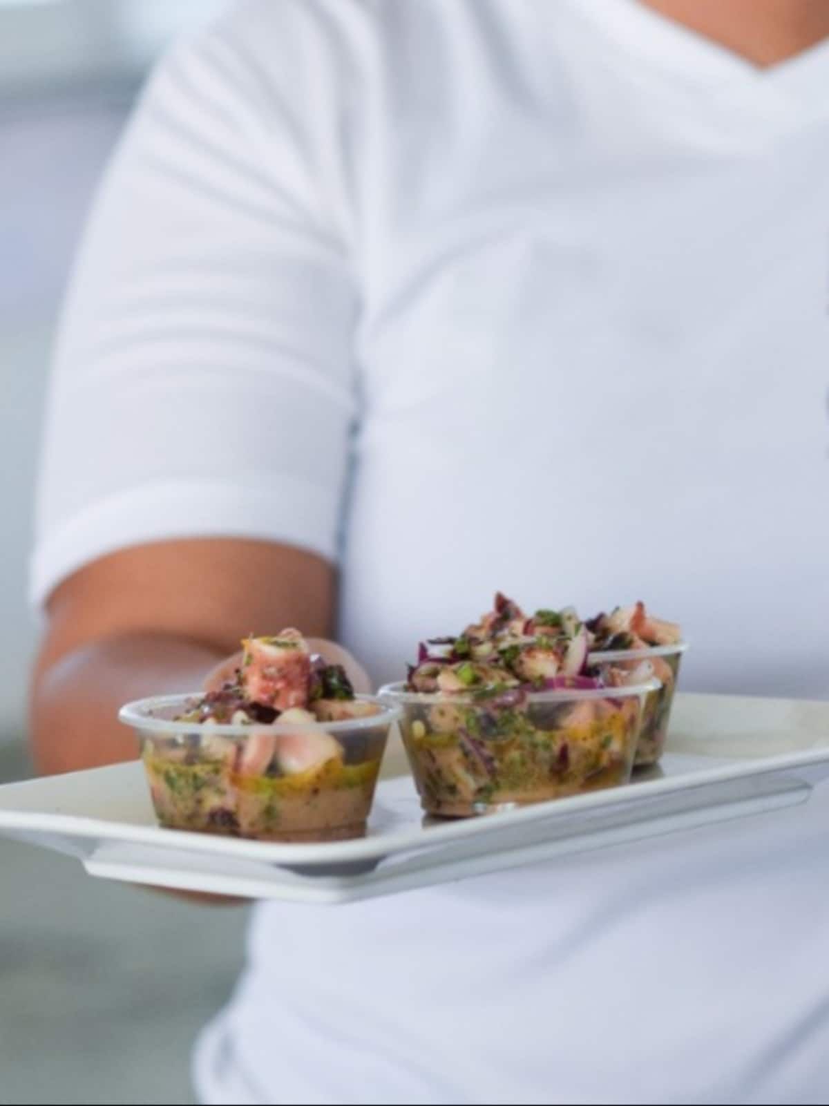 Server holding a tray with three cups of fresh ceviche during the Panama City Markets Food Tour by Bandits Adventure Tours Panama.