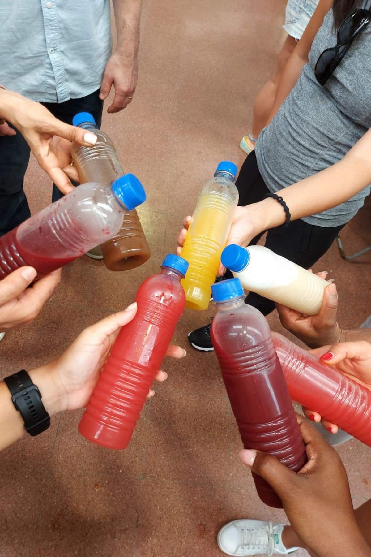 Group of people sharing colorful bottled drinks during a Panama City Markets Food Tour, showcasing local flavors and community experience.