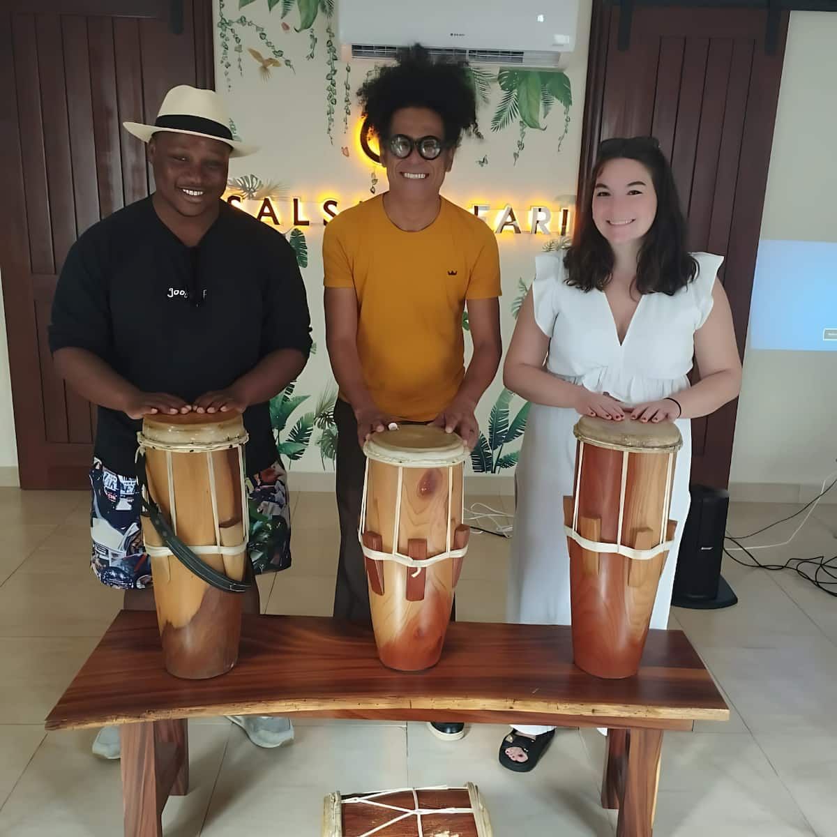 Three people enjoying a traditional drumming session during the Panama Drumming Experience in Panama City, Panama.