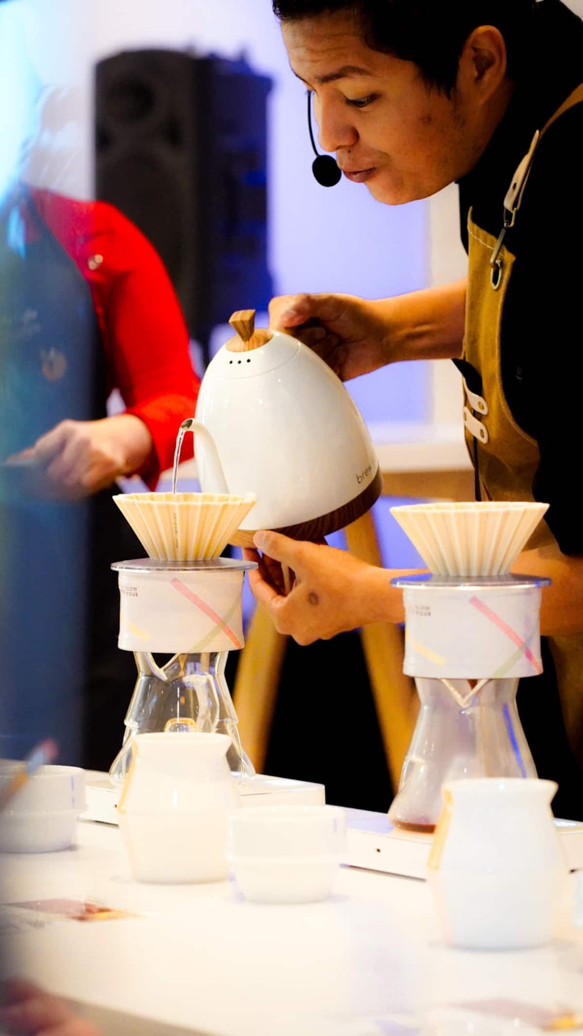 Barista pouring hot water into a coffee dripper during a Panama Geisha Specialty Coffee Tasting Experience in Panama City, Panama.