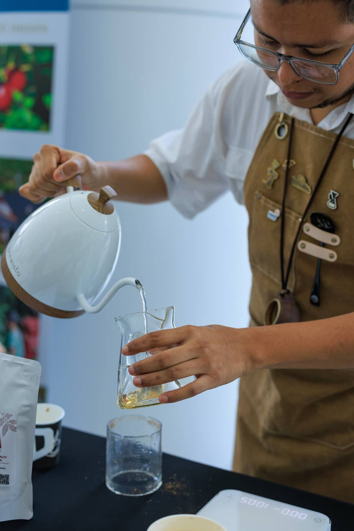 Barista pouring Panama Geisha specialty coffee into a glass carafe during a tasting experience in Panama City.