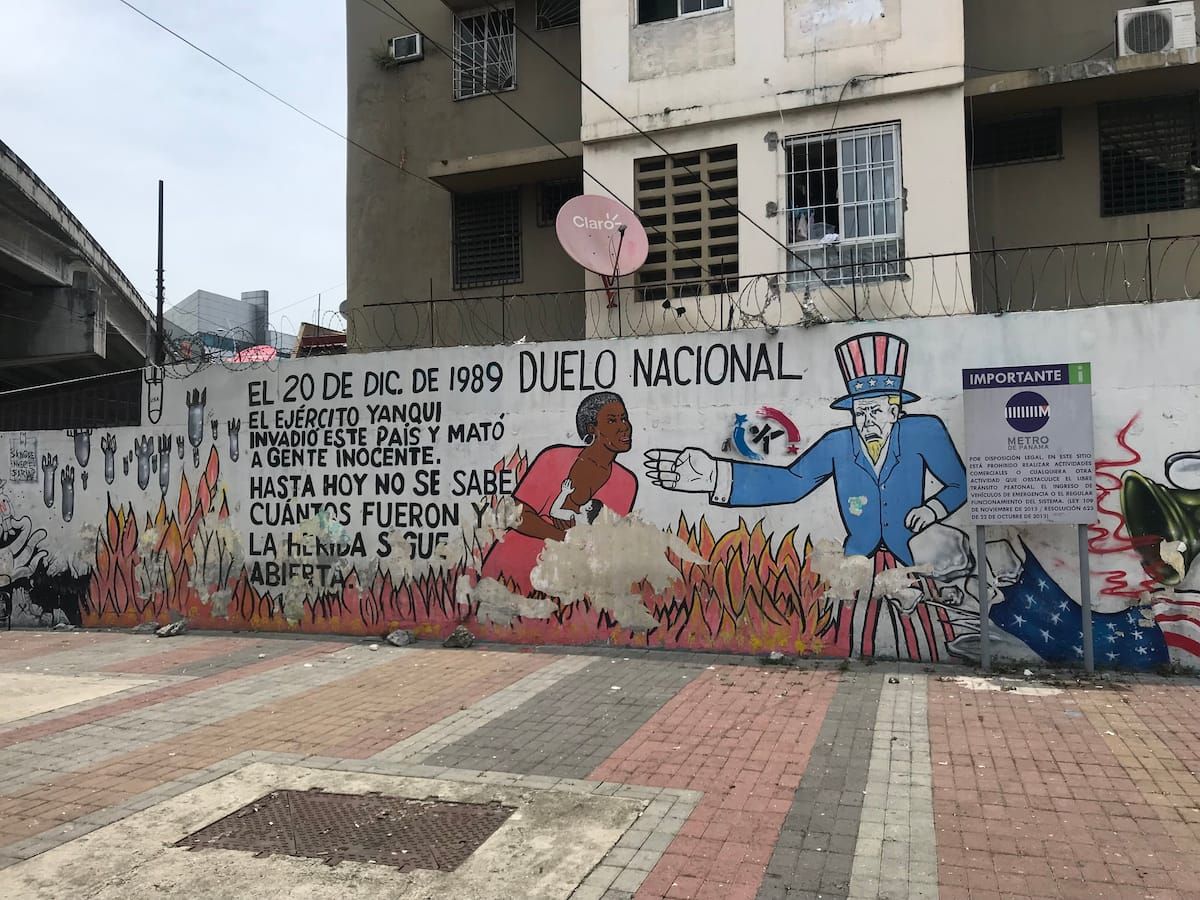 A mural in Panama City commemorating the U.S. invasion of December 20, 1989, depicting Uncle Sam and a grieving woman amidst flames and bombs.
