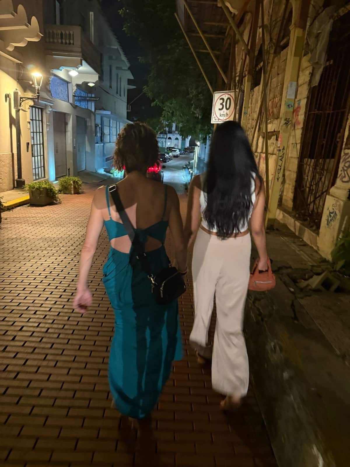 Two women exploring the historic streets of Casco Viejo at night during a Rumba Panamanian Style tour in Panama City.