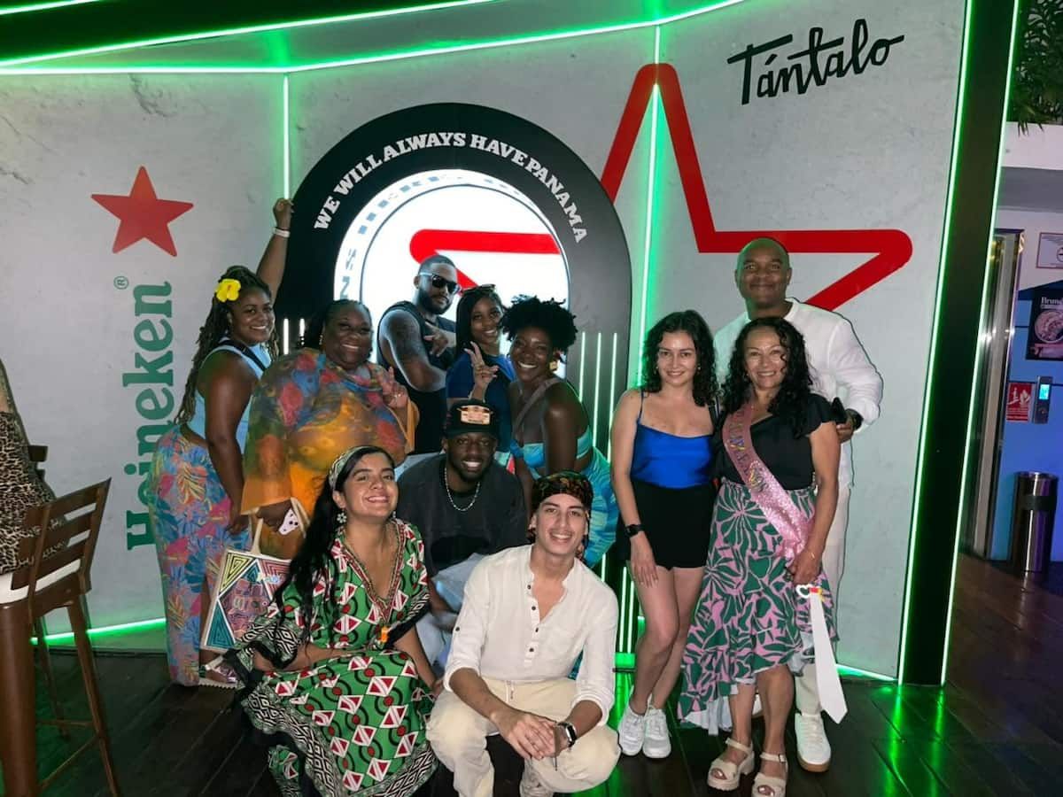 Group of people posing for a photo in front of a vibrant backdrop featuring the Heineken logo and 'We Will Always Have Panama' arch at Tántalo in Panama City, Panama.