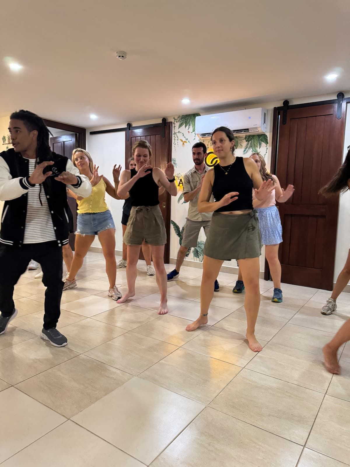 Group of people learning salsa dance steps in an indoor studio led by an instructor, part of a Salsa Lesson Dinner experience in Casco Viejo, Panama.