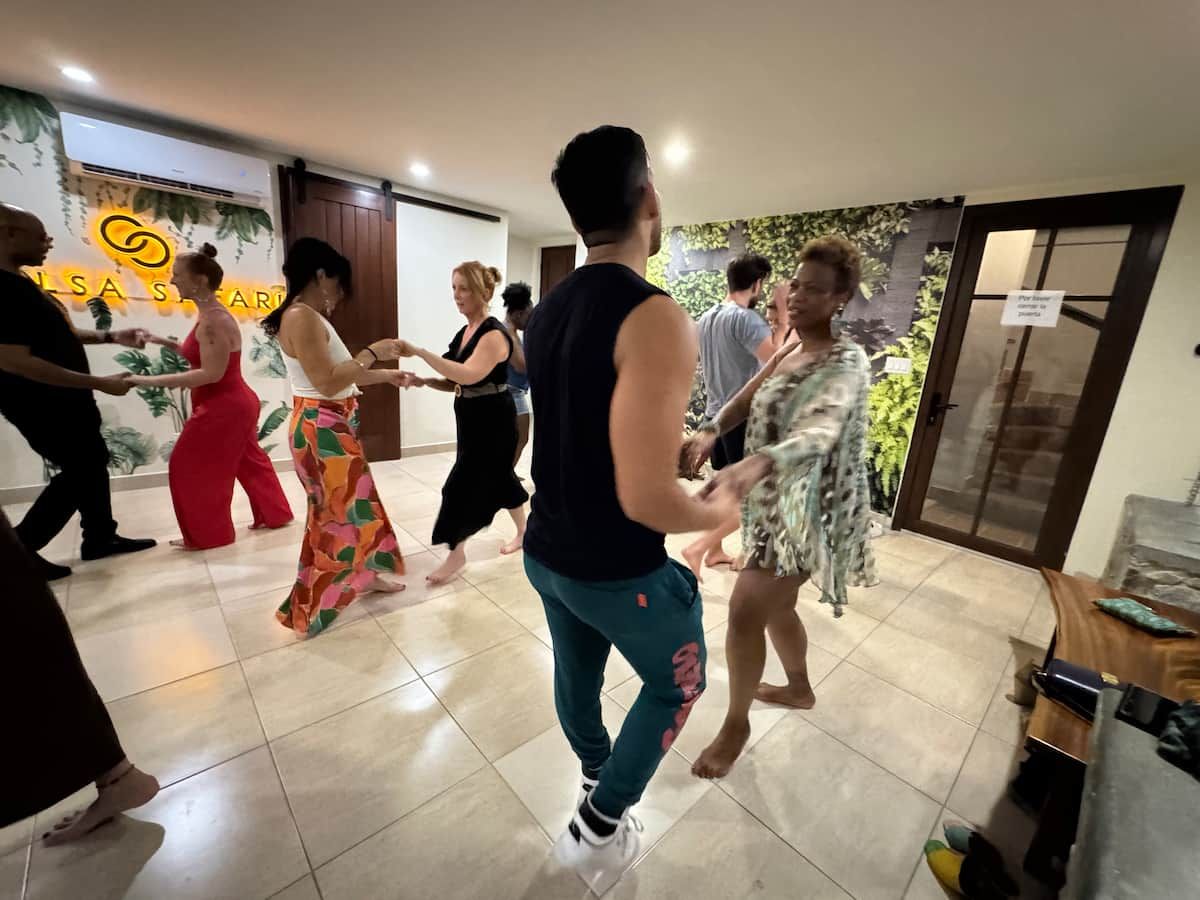 Group of people learning salsa dance moves in a vibrant studio setting during a tour in Panama City, Panama.