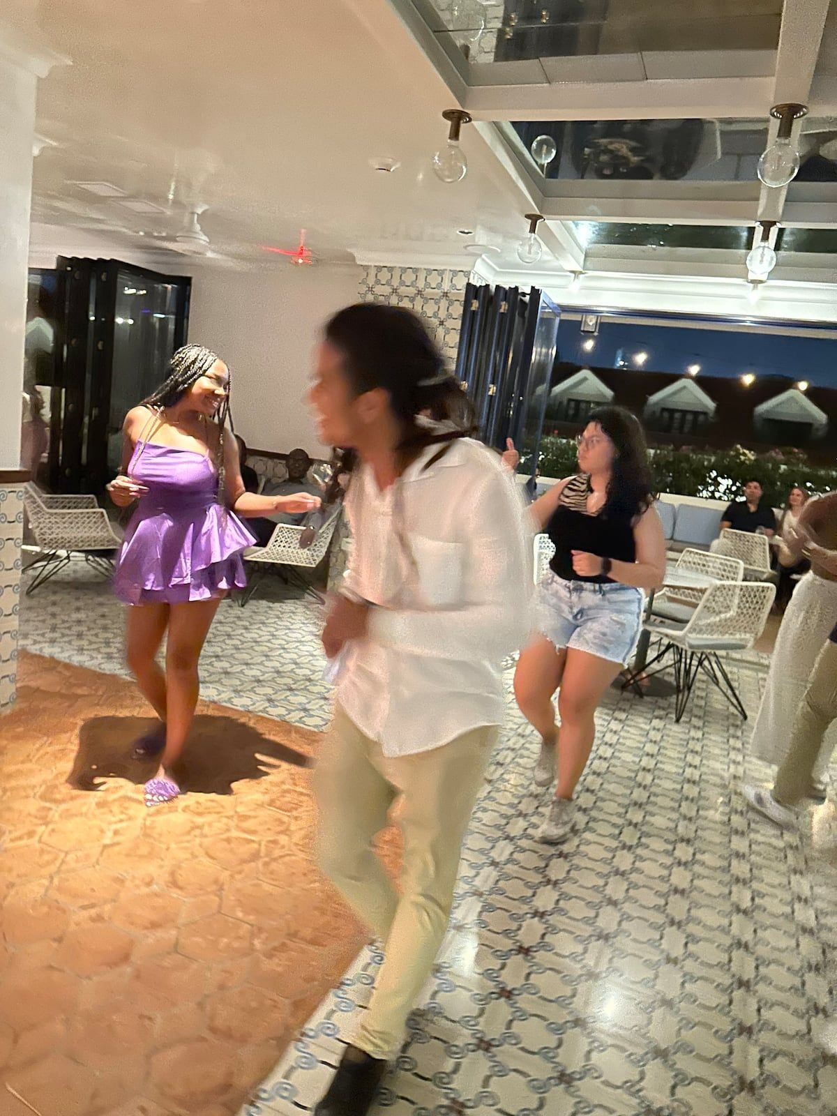 People dancing salsa during a lesson in Casco Viejo, Panama City, under the evening sky with a festive atmosphere.