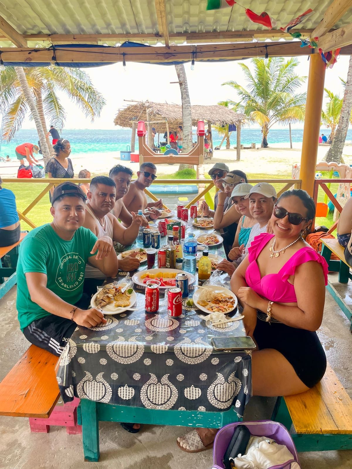 Group of friends enjoying a meal at a beachside restaurant during the San Blas Islands Day Trip in Panama City, Panama.