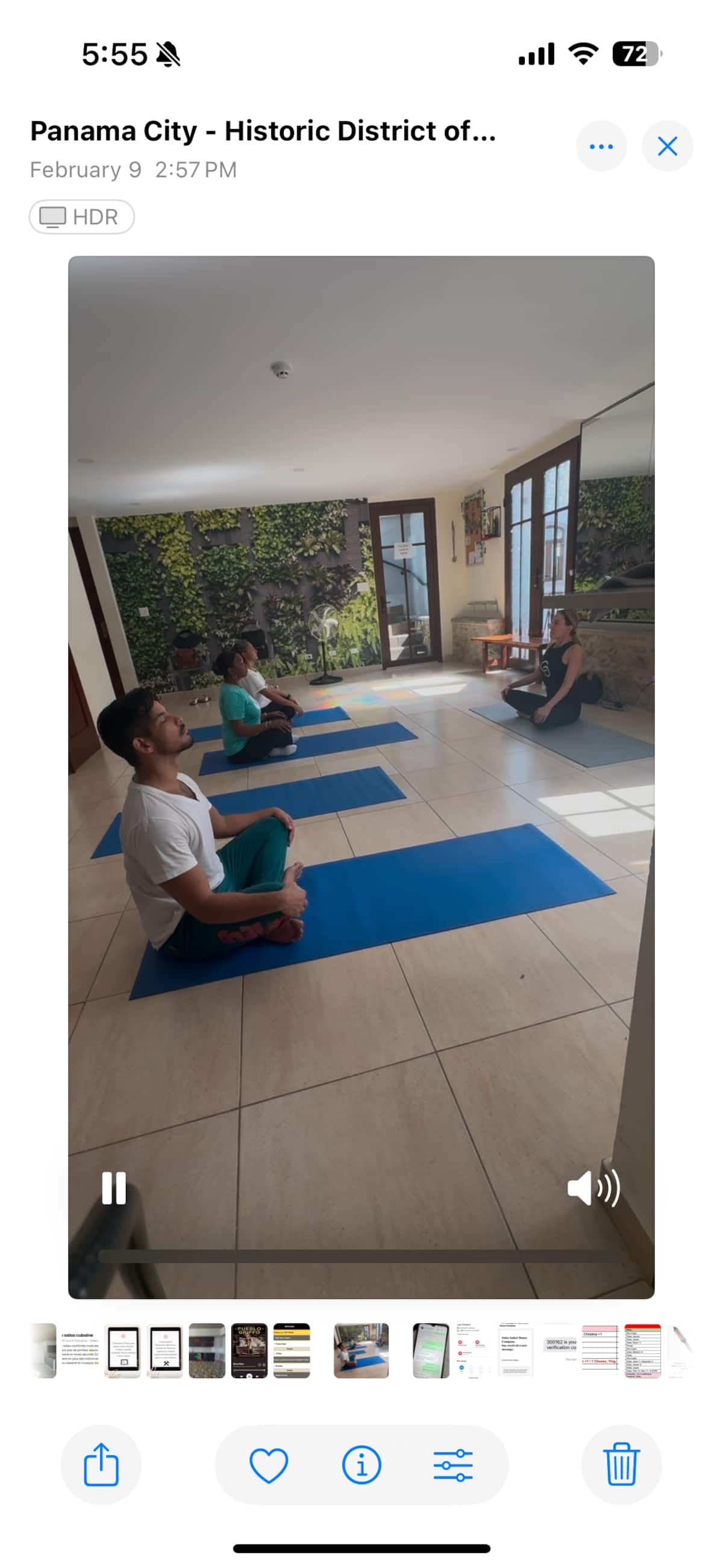 Participants practicing yoga on blue mats in a serene indoor studio with a green living wall backdrop in Panama City's Historic District.