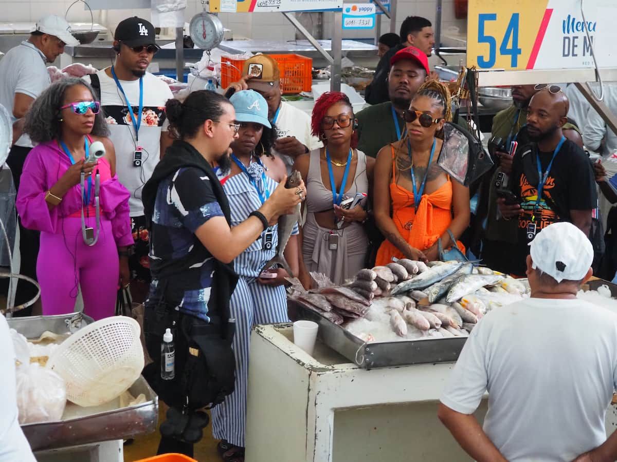 Tour guide explaining fresh seafood to a group of tourists at a vibrant market in Panama City, Panama.