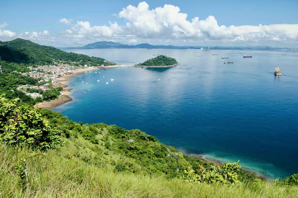Scenic view of Taboga Island from a hillside, featuring lush greenery, turquoise waters, and a picturesque beachfront in Panama City