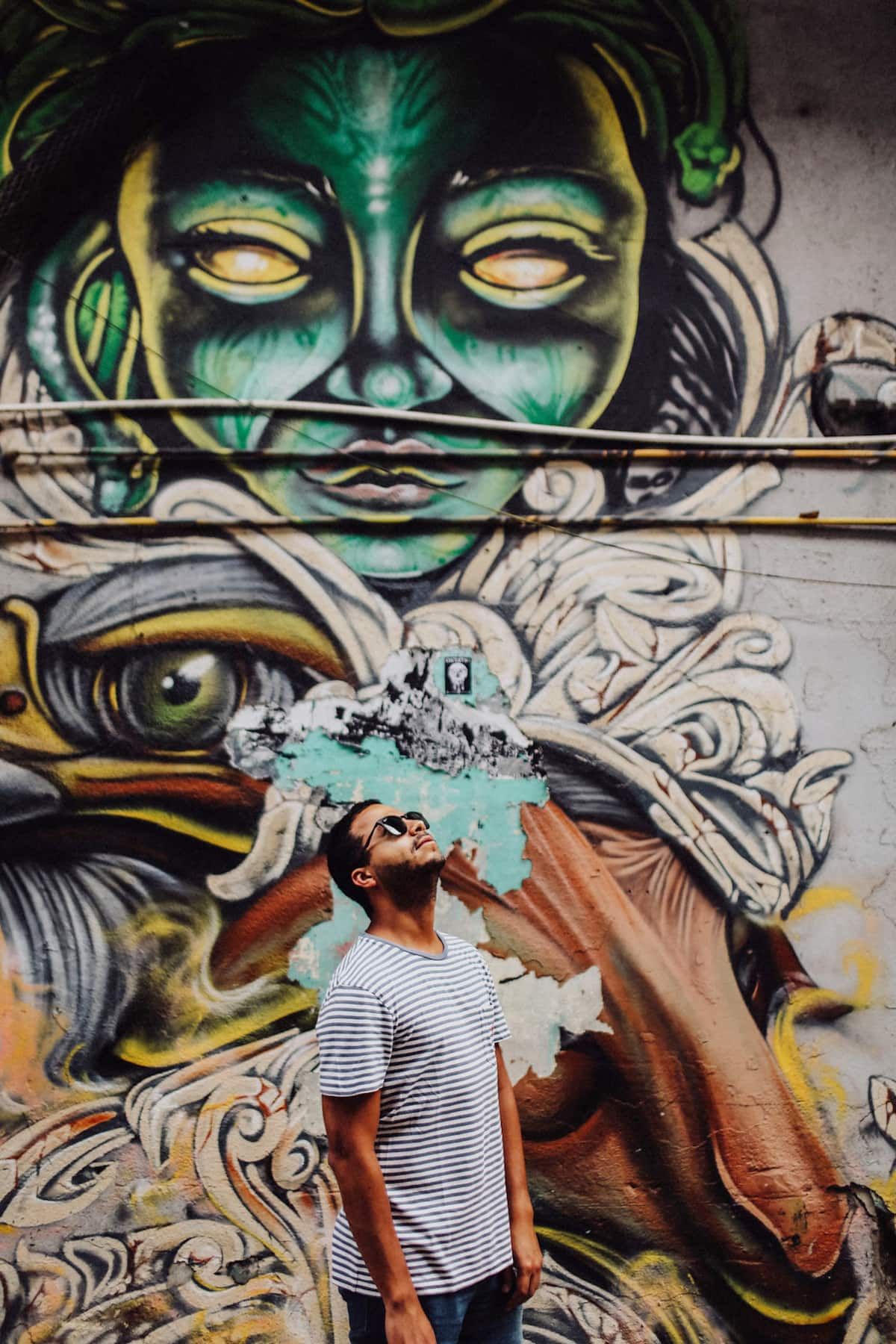 Man in sunglasses admiring colorful graffiti art during a rooftop food tour in Panama City